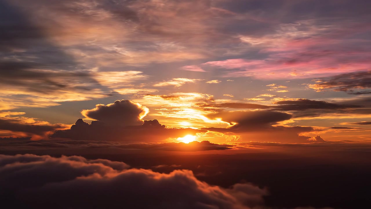 Atemberaubender goldener Sonnenuntergang über einem Wolkenmeer aus großer Höhe