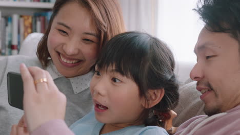 happy asian family having video chat using smartphone at home mother and father with daughter chatting on mobile phone together waving hand enjoying online communication 4k footage