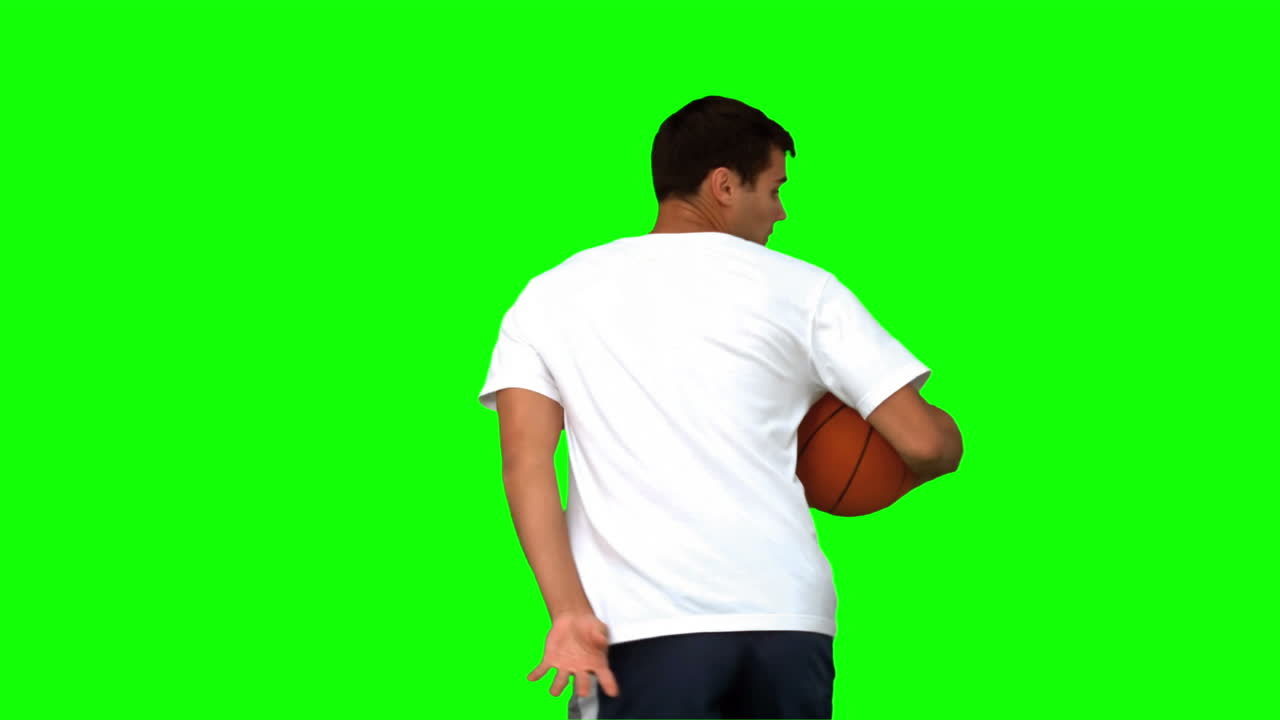 hombre driblando con una pelota de baloncesto en la pantalla verde
