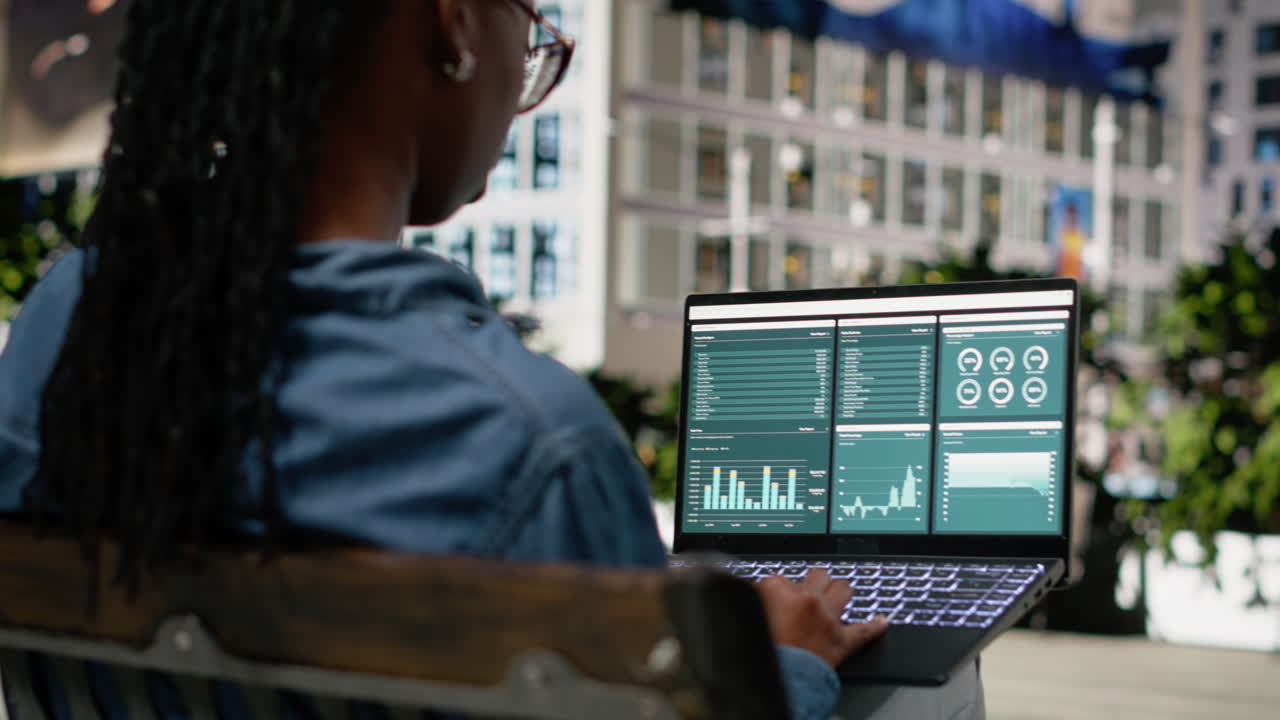 Digital nomad on park bench analyzing business charts and infographics