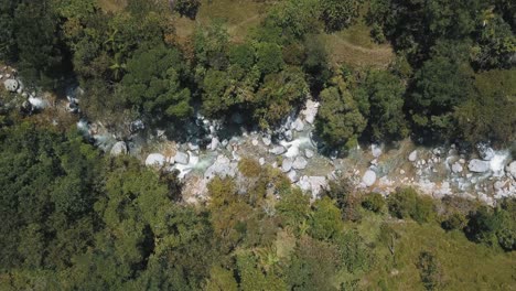 River-with-huge-rocks-and-water-flowing-in-a-forest---bird's-eye-drone-aerial-view-near-Guatape-area-in-Colombia