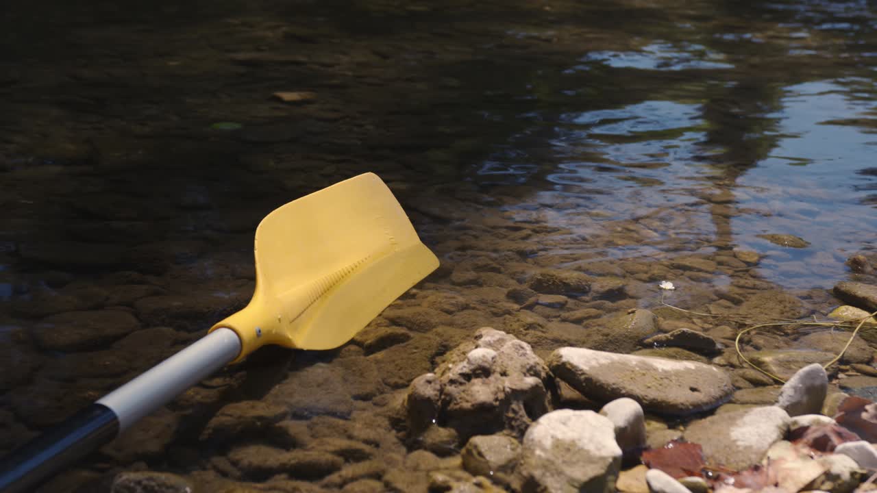 Canoe Paddle Lying On The Rocky Lakeshore