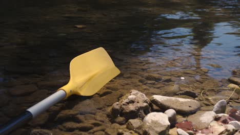 canoe paddle lying on the rocky lakeshore