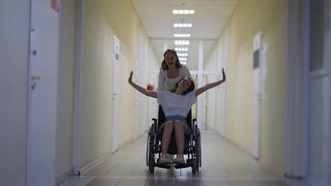 mujer feliz corre empujando silla de ruedas con hermana discapacitada