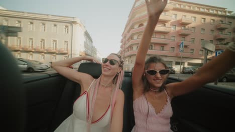 two women enjoying a convertible ride in the city