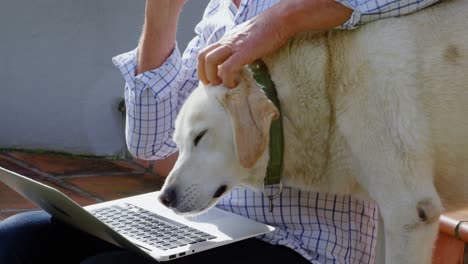 senior man talking on mobile phone while using laptop 4k