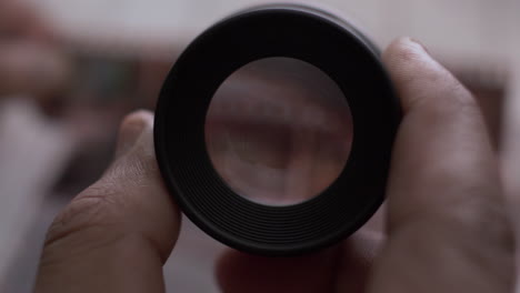 pov looking through handheld loupe magnifier at 35mm photo negatives