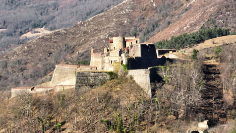 From-the-skies,-witness-the-majestic-Fort-Lagarde-basking-in-Prats-de-Mollo's-su