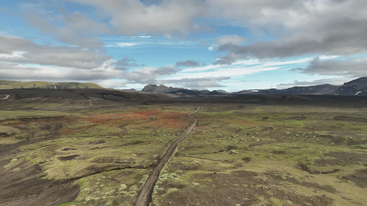 carretera de tierra en el paisaje con montañas y nubes aérea islandia