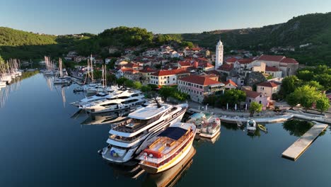 Aerial-drone-video-slowly-flying-backwards-and-away-from-the-old-town-of-Skradin-in-Croatia,-revealing-the-surrounding-landscape