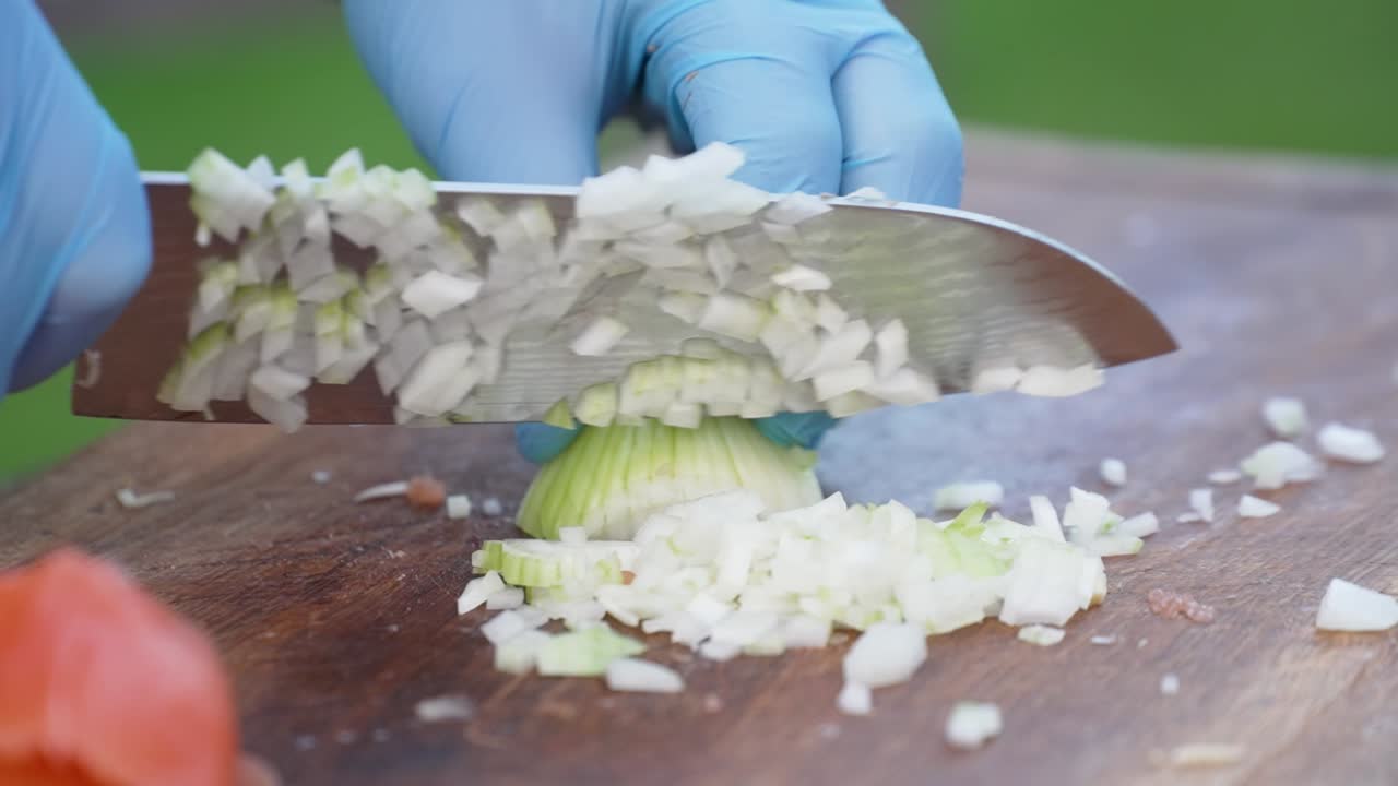 Close-up of cutting an onion into small pieces in slow motion