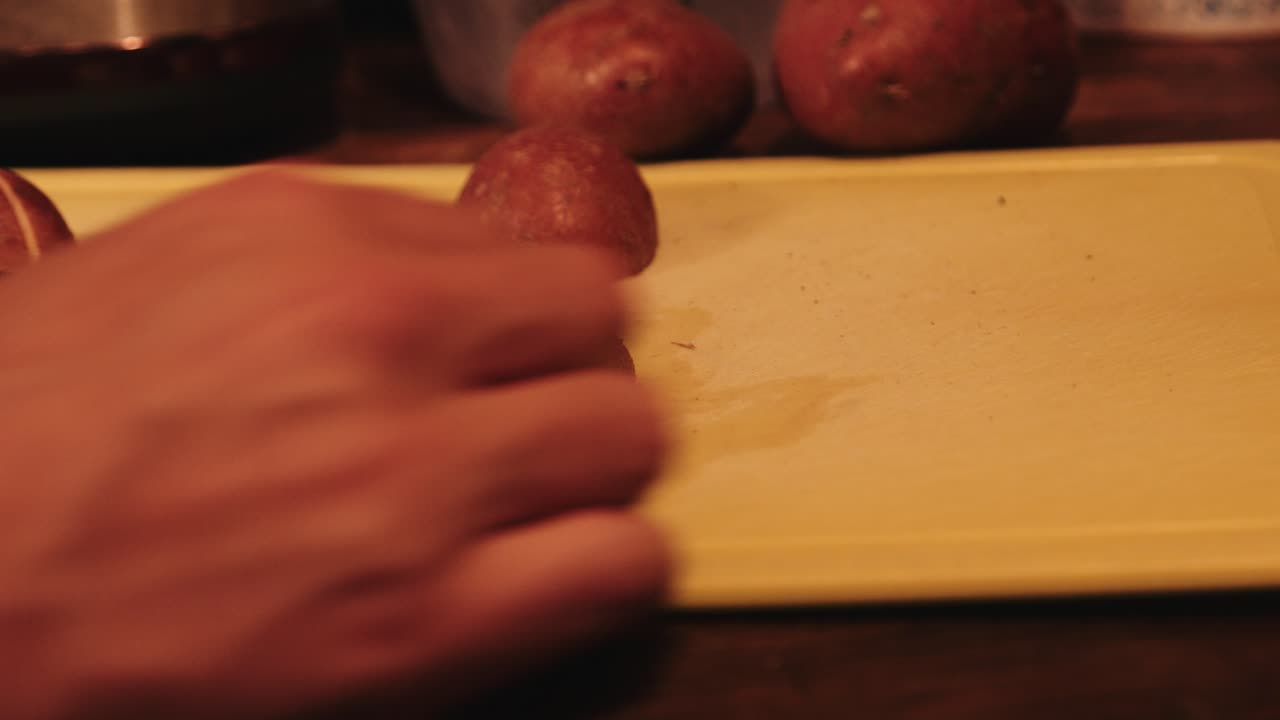 chef cortando patatas rojas crudas para hacer cuñas de patata picantes