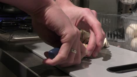 deft hands cutting champignon in front of gas stove top