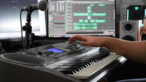 young technician sets up a keyboard for recording in a home studio