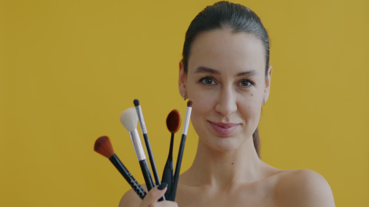 Woman Holding Makeup Brushes