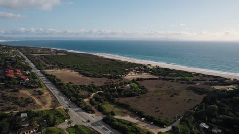 Drone-shot-of-the-E-5-motorway-driving-along-the-coast-of-Tarifa,-Spain