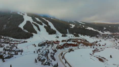 foggy cloud layers winter snowy early morning sunrise aerial drone copper mountain colorado ski resort village eagle flyer super bee lift ikon epic pass cars on road snowboarding ski forward