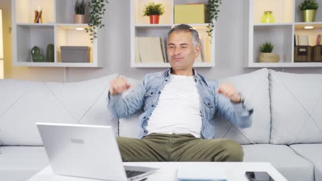 el hombre mira la computadora portátil y se alegra.
