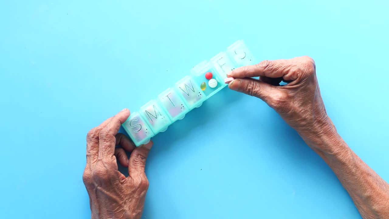 주간 알약 분배기를 사용하는 노인