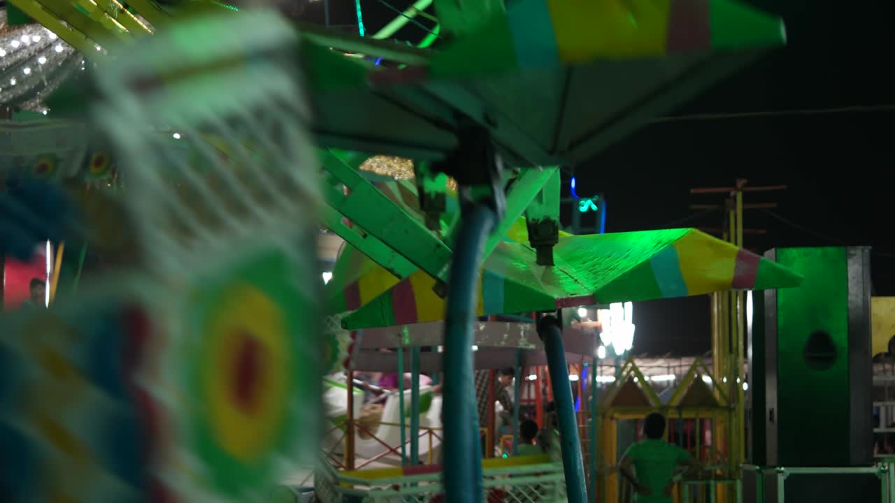 carnaval con rueda gigante, luces de colores brillantes, carrusel de coches en primer plano nocturno