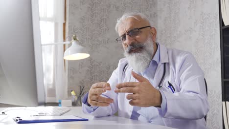 médico sénior llevando a cabo una videoconferencia.