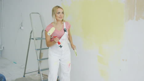 Blond-female-with-paint-roller-dancing-
