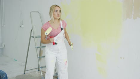 blond female with paint roller dancing