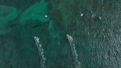 aerial view of windsurfers and kitesurfers in turquoise water