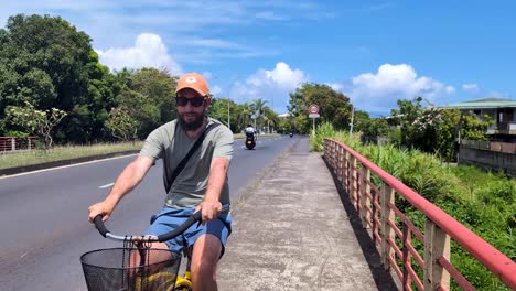 tourist on holiday cycling on lowrider bicycle towards belvedere lookout in tahiti, french polynesia, south pacific