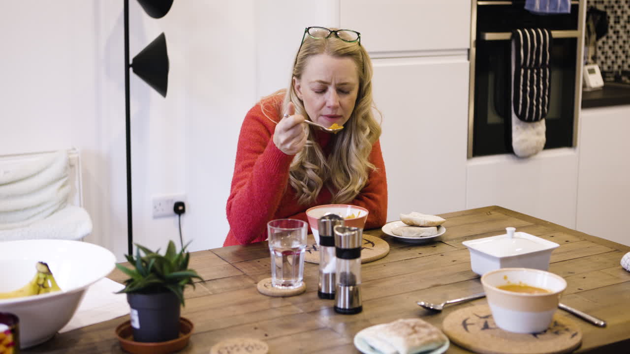 Woman Eating Soup at Kitchen Table