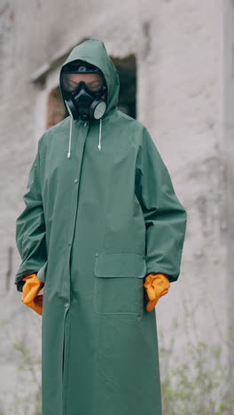 human in radioactive green suit and gas mask. guy wearing hazmat suit and gloves. vertical video
