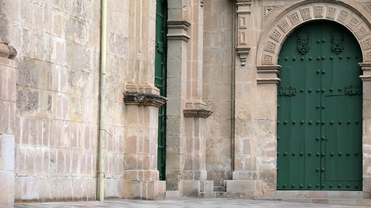 exterior de la catedral de cajamarca con puerta lateral cerrada y tallas de piedra en arquitectura de estilo barroco