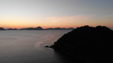 Silueta-De-Montañas-Costeras-Junto-A-La-Tranquila-Costa-Del-Mar-Durante-La-Puesta-De-Sol-En-El-Nido,-Palawan,-Filipinas