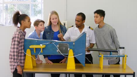 piloto masculino explicando sobre la máquina a los niños 4k