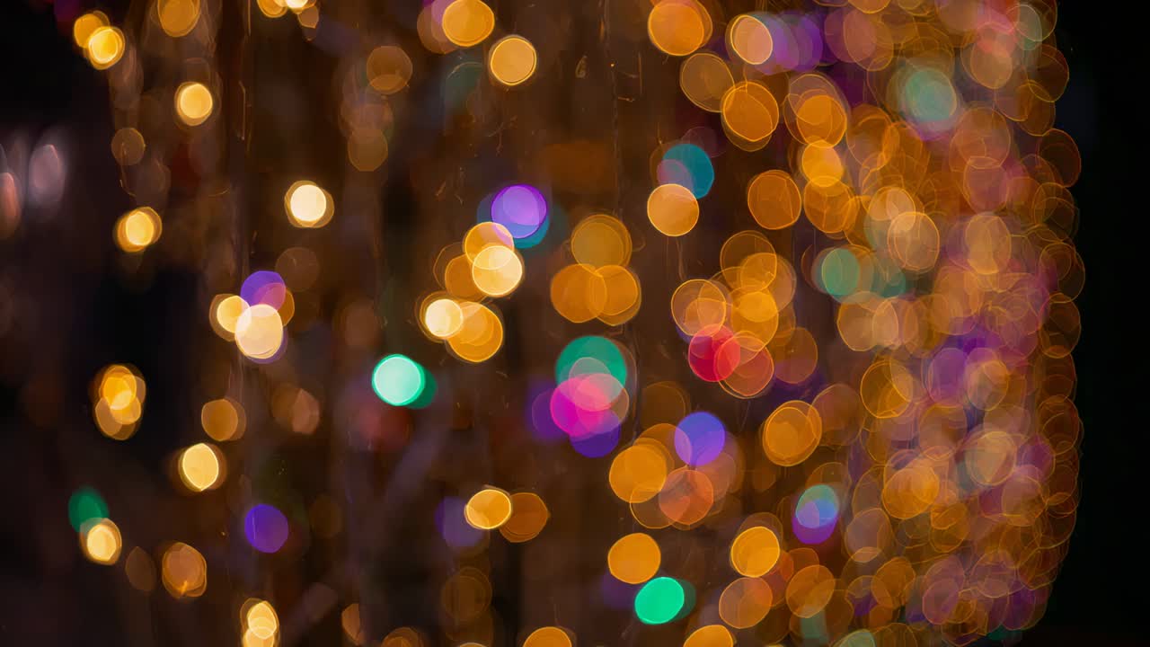 Recording cam capturing blurred decorative string lights in dim night, making bokeh for decor