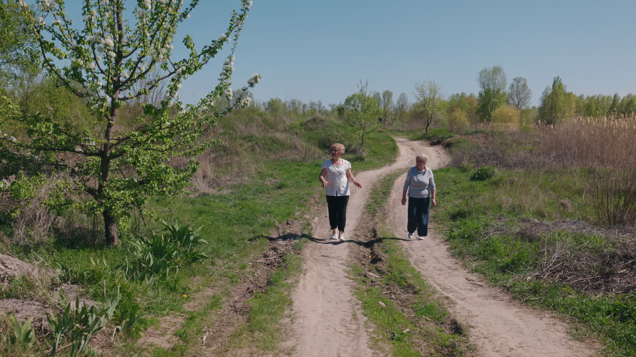Two women walking on a country road in spring