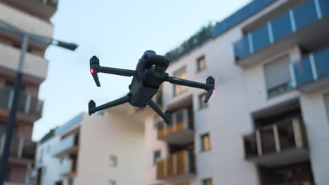 close-up of mavic quadcopter drone in static flight with residential buildings in background