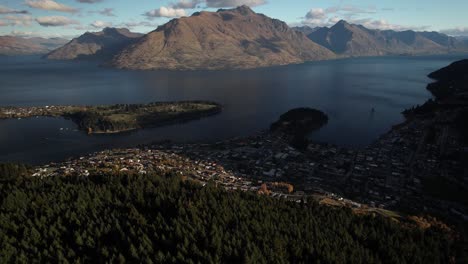 Aerial-panoramic-of-Queenstown-settlement-and-lakefront-of-Lake-Wakatipu,-evening-in-New-Zealand