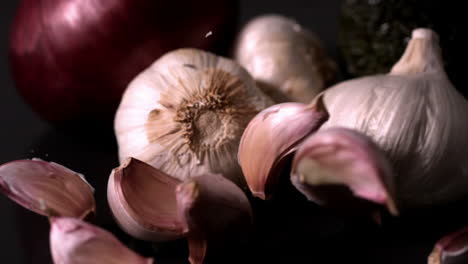 Garlic-falling-against-black-background