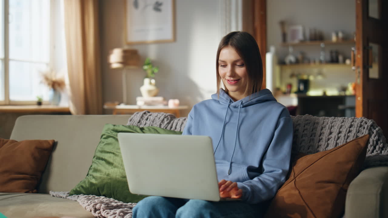 Woman using laptop on couch at home