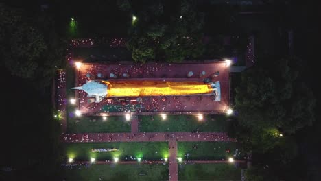 bird eye view of peoples walking with candle light around bigh buddha image