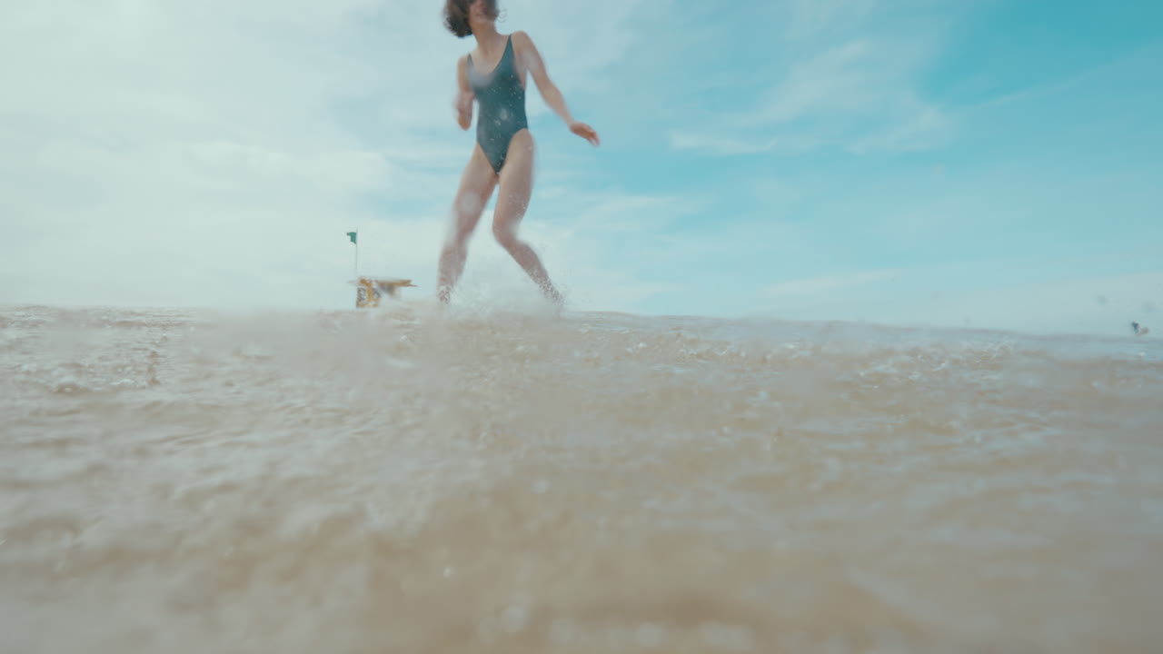 Woman running in the waves at the beach