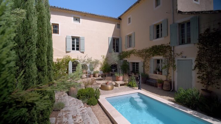 Jardin ouvert et espace piscine d'une villa méditerranéenne rustique dans le sud de la France, prise de vue aérienne en travelling avant