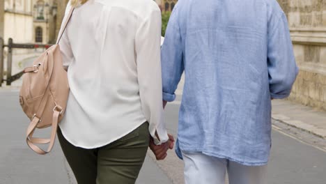 middle aged couple holding hands on street