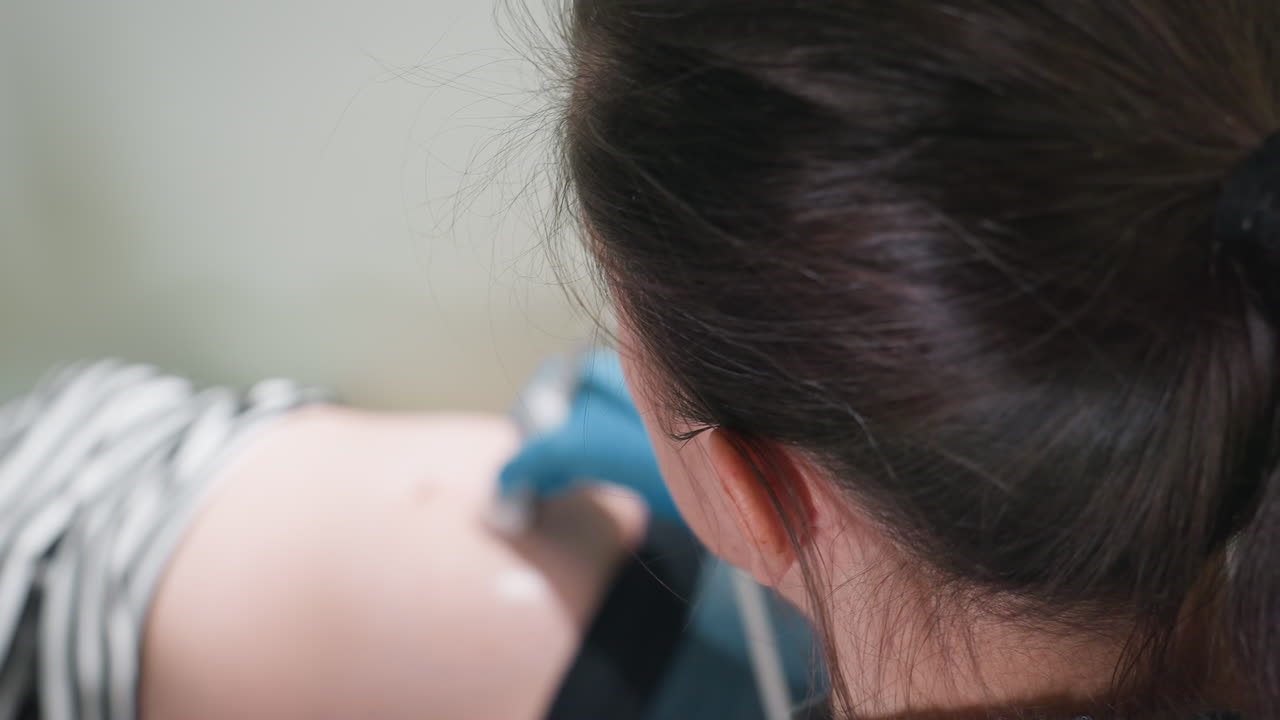 aerial view of clinical laboratory specialist scanning patient belly while attentively observing monitor display for accurate imaging results during real-time diagnostic ultrasound session
