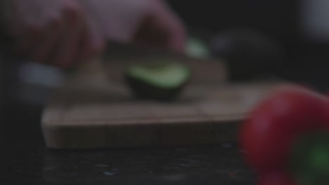 slowmo dicing avocado on cutting board, closeup dolly in with rack focus