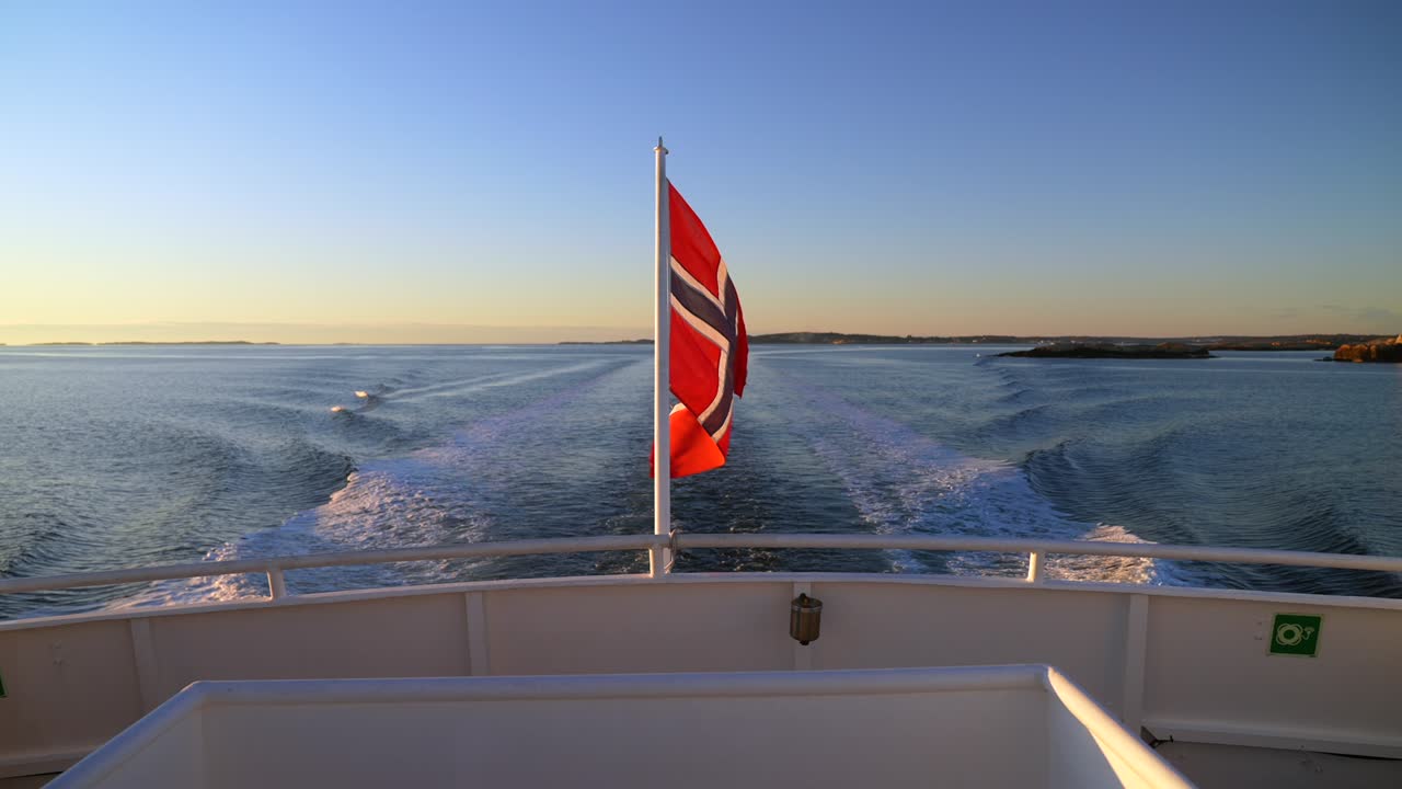 Norwegian Flag wind on ferry Boat ride wake Strömstad Stromstad Oslo Fjord Sweden Sverige Norway Norge golden hour Arctic sunlight sunset Scandinavia islands horizon Natural preserve area coastline