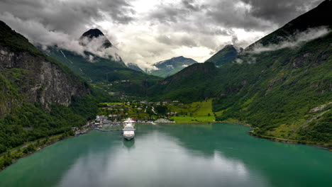 Vista-Aérea-De-Hiperlapso-Del-Crucero-Atracado-En-El-Pintoresco-Fiordo,-Geiranger,-Noruega