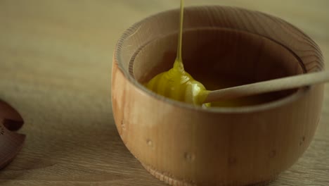 Thick-honey-dripping-from-the-spoon,-close-up.-Honey-flowing-honey-from-a-spoon