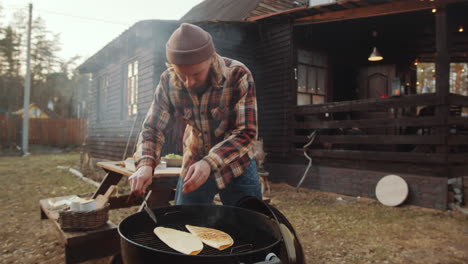 man cooking tortillas on bbq grill